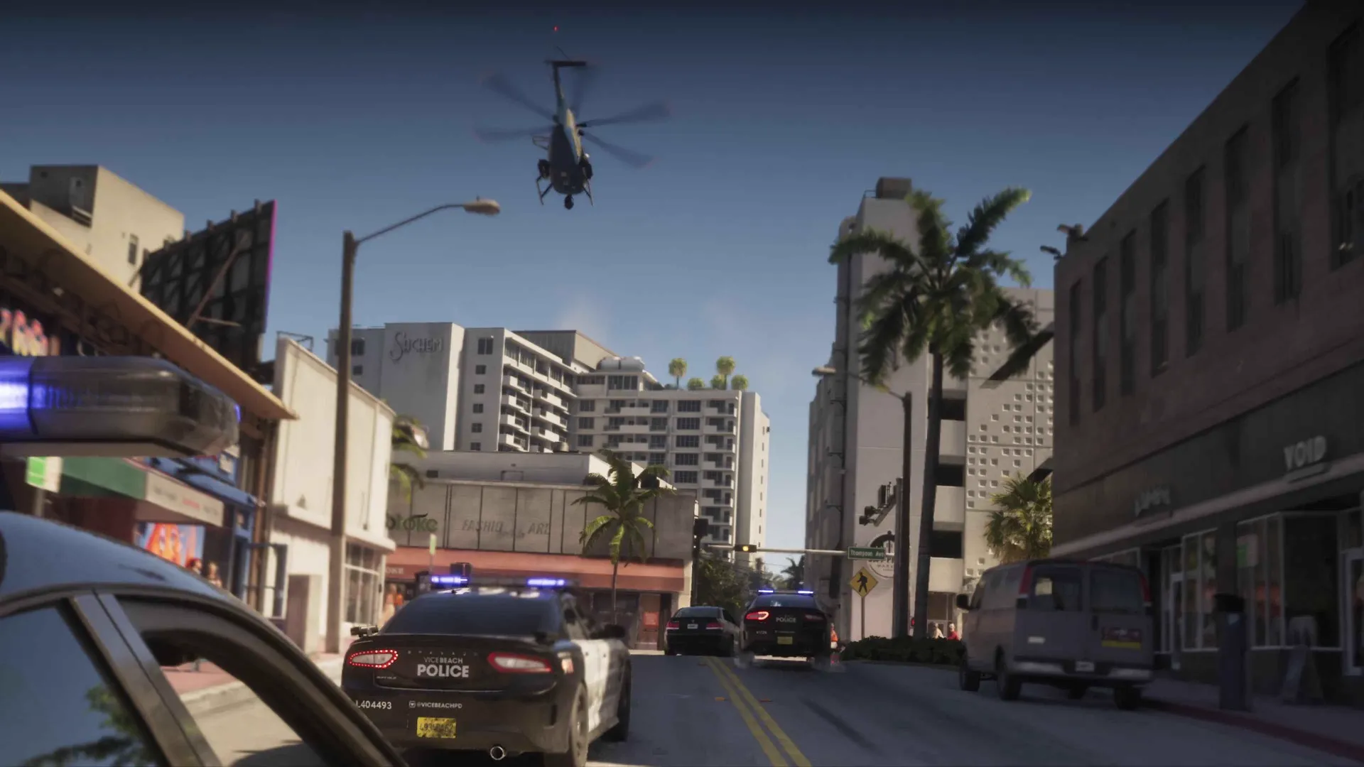 Hélicoptère et voitures de police convergent vers un carrefour bordé de palmiers dans GTA 6